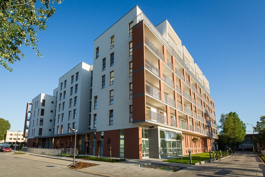 Nowe Miasto Pruszków, narożnik elewacji z czerwoną cegłą klinkierową i balkonami