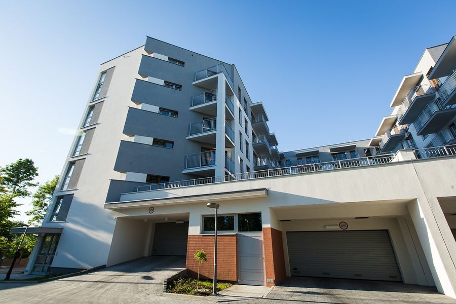 Nowe Miasto Pruszków, narożnik białej elewacji z wjazdami do garaży podziemnych