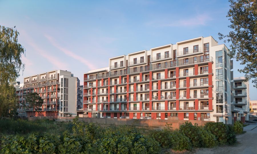 Nowe Miasto Pruszków, dwa budynki osiedla z czerwoną cegłą klinkierową, widok od zieleni