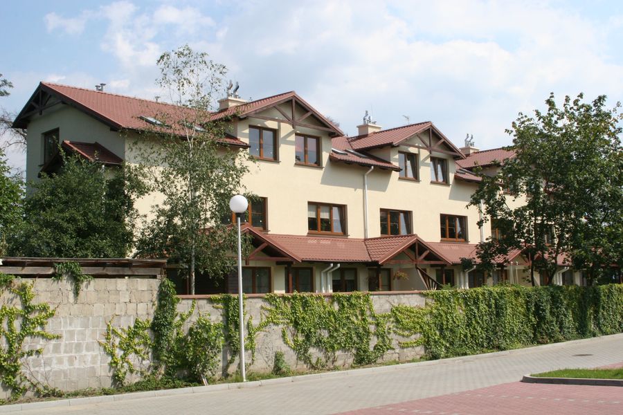 Reymonta, elewacja frontowa zabudowy szeregowej za murem obrośniętym bluszczem