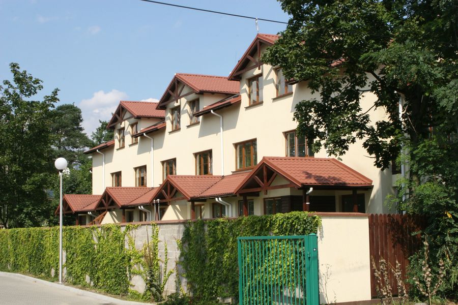Reymonta, rząd domów szeregowych z czerwonymi dachami, widok od ulicy