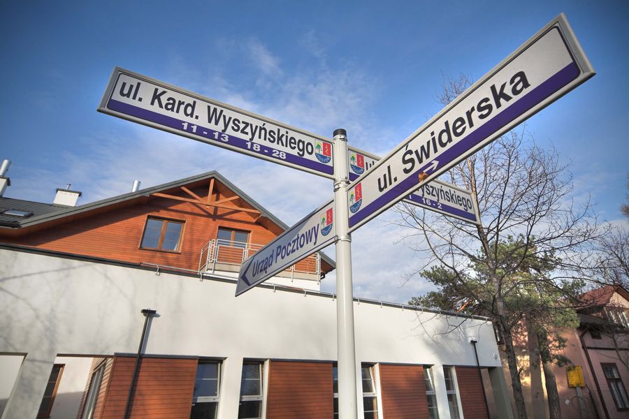 Skrzyżowanie ulic Świderska i Kard. Wyszyńskiego w Józefowie, drogowskaz przy siedzibie AIPP